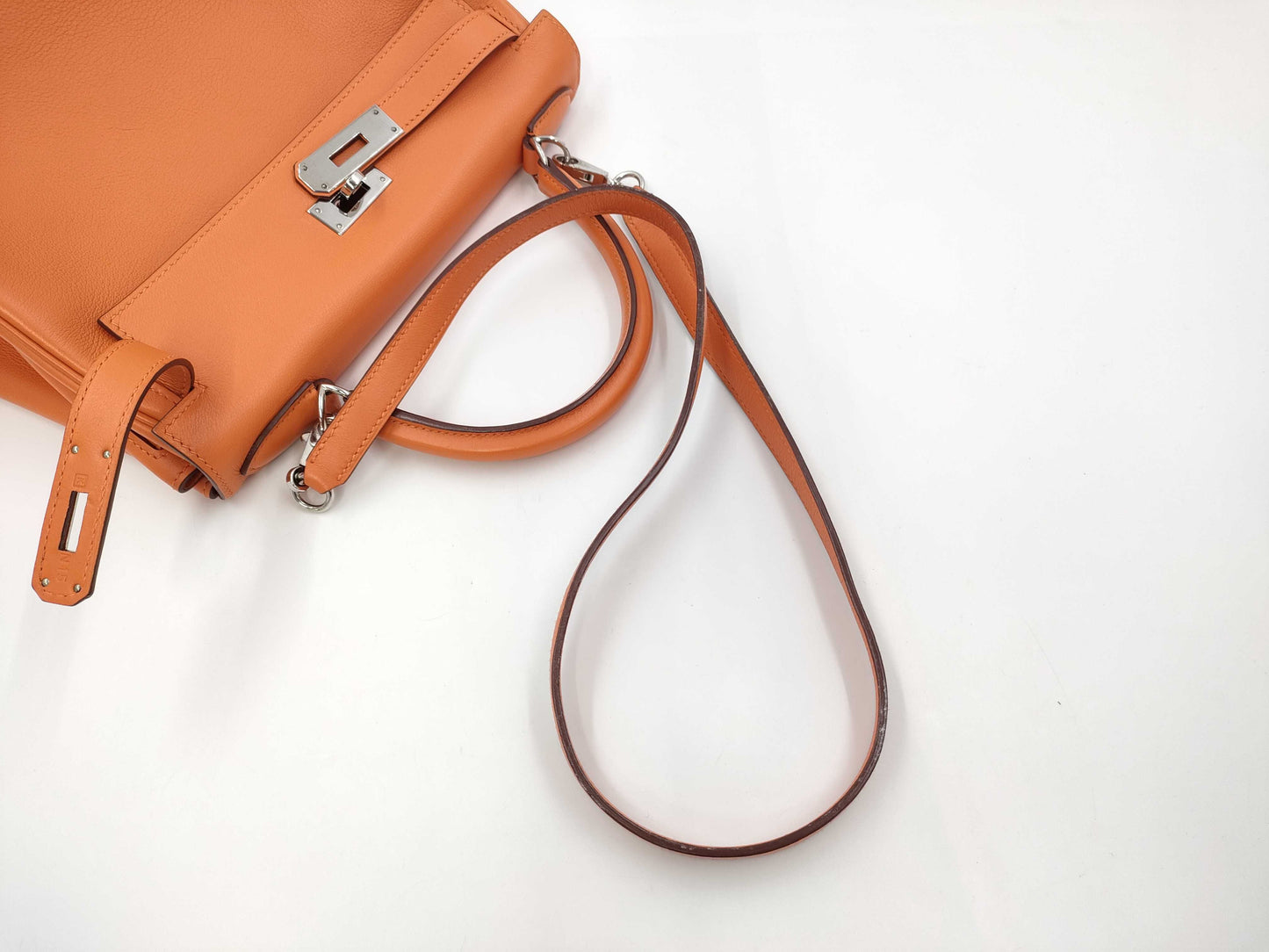 HERMES Kelly 28 handbag with silver hardware, inner stitching, orange Taurillon leather, K stamped.
