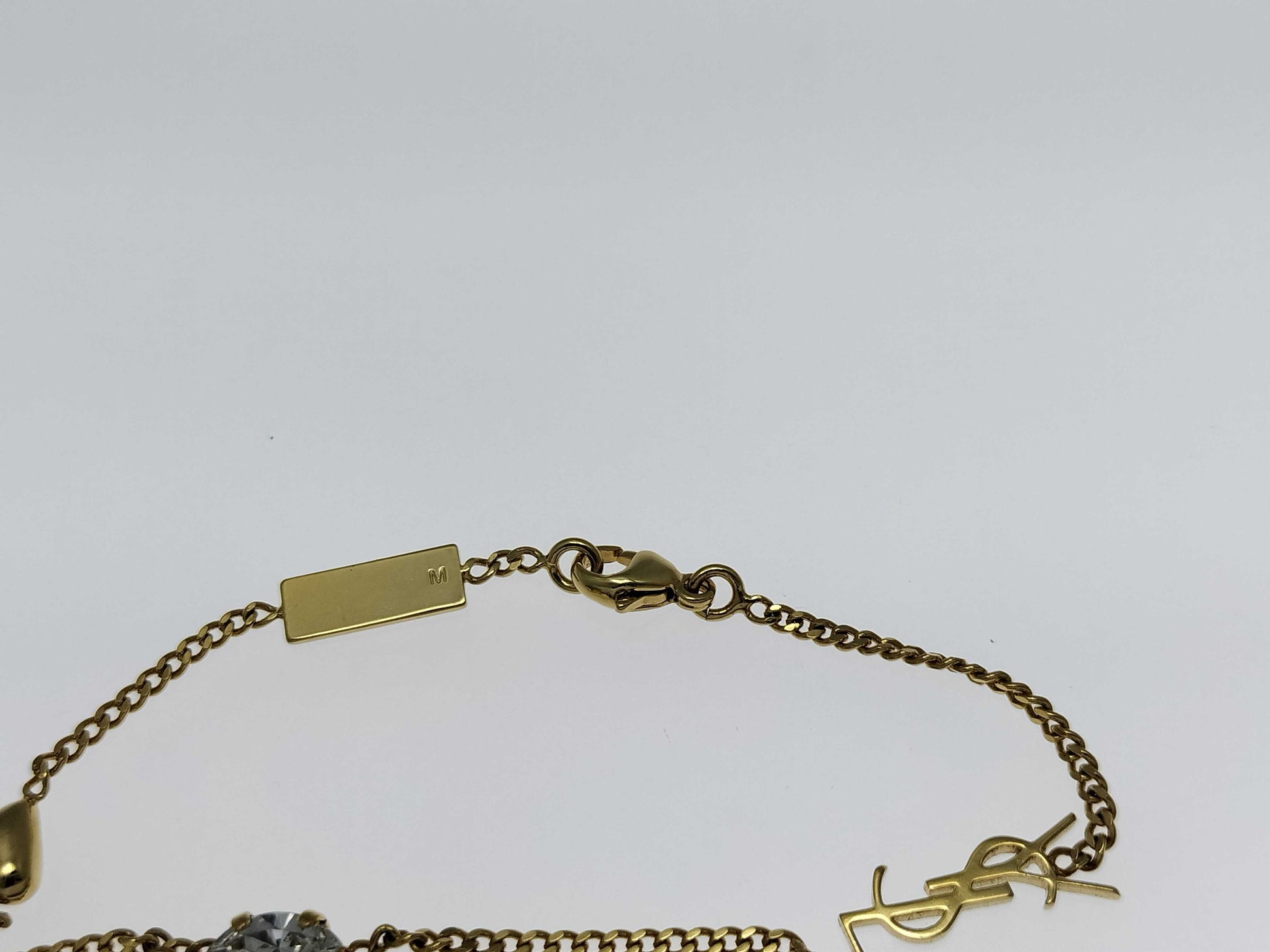 Yves Saint Laurent YSL Logo Cassandra Heart Charm Bracelet in Gold with Rhinestones. Includes Box and Dust Bag.