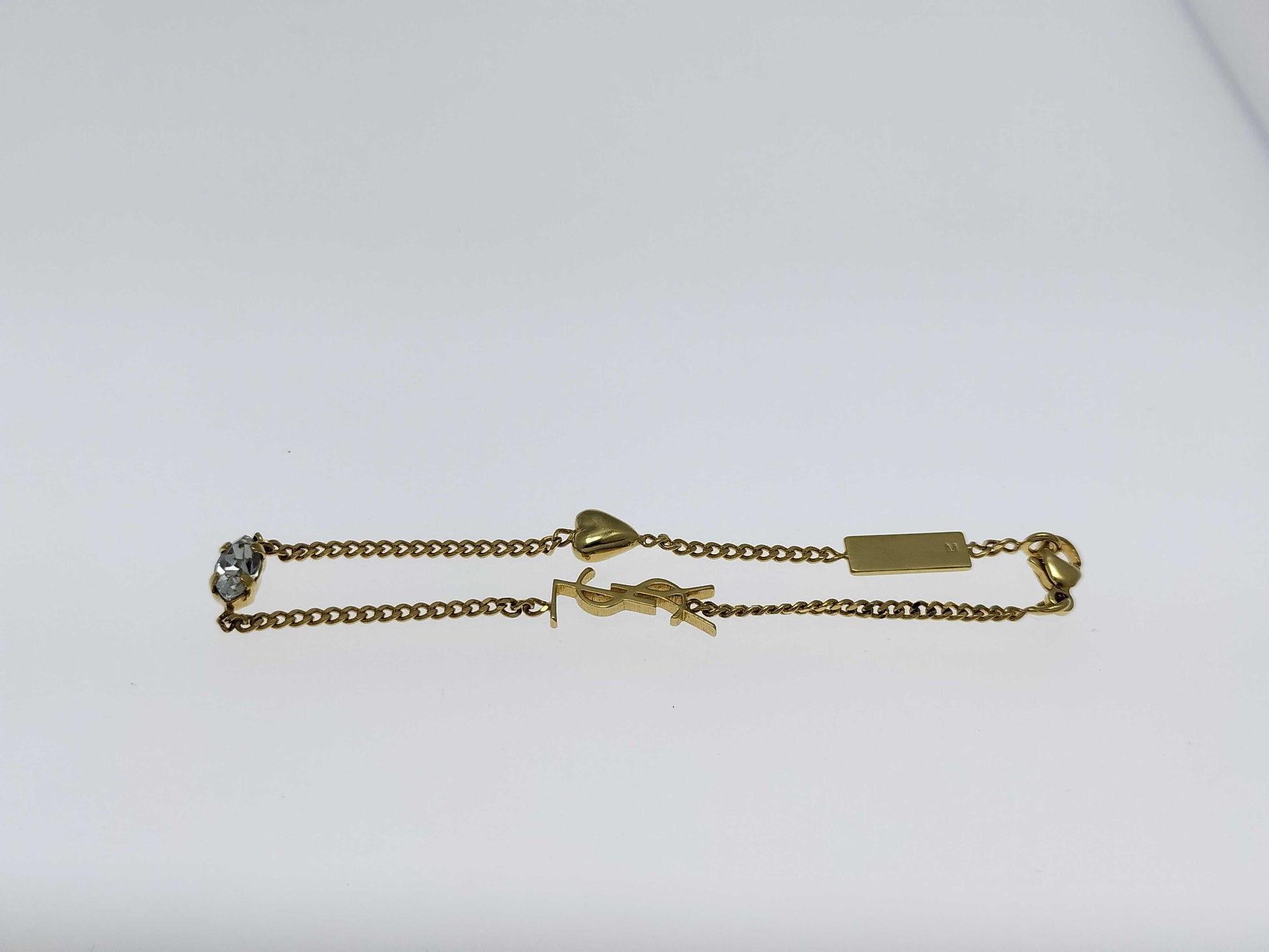 Yves Saint Laurent YSL Logo Cassandra Heart Charm Bracelet in Gold with Rhinestones. Includes Box and Dust Bag.