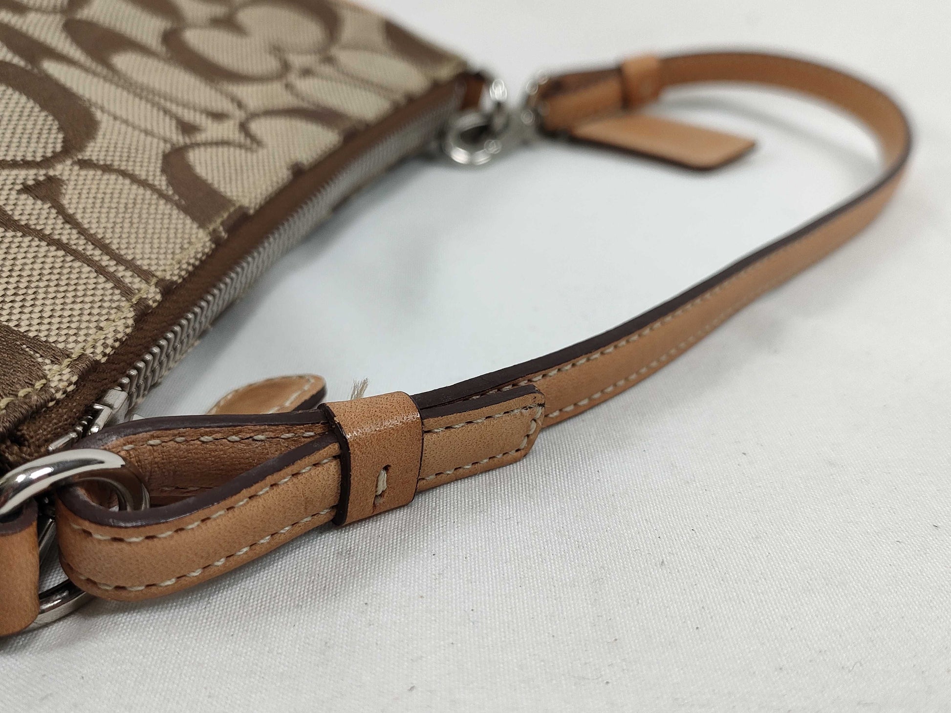COACH Signature Stripe Patent Leather Accessory Pouch in Light Brown Canvas with Logo Charm.