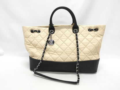 CHANEL Drawstring Shopping Tote, Beige/Black Quilted Lambskin Leather with Silver Hardware