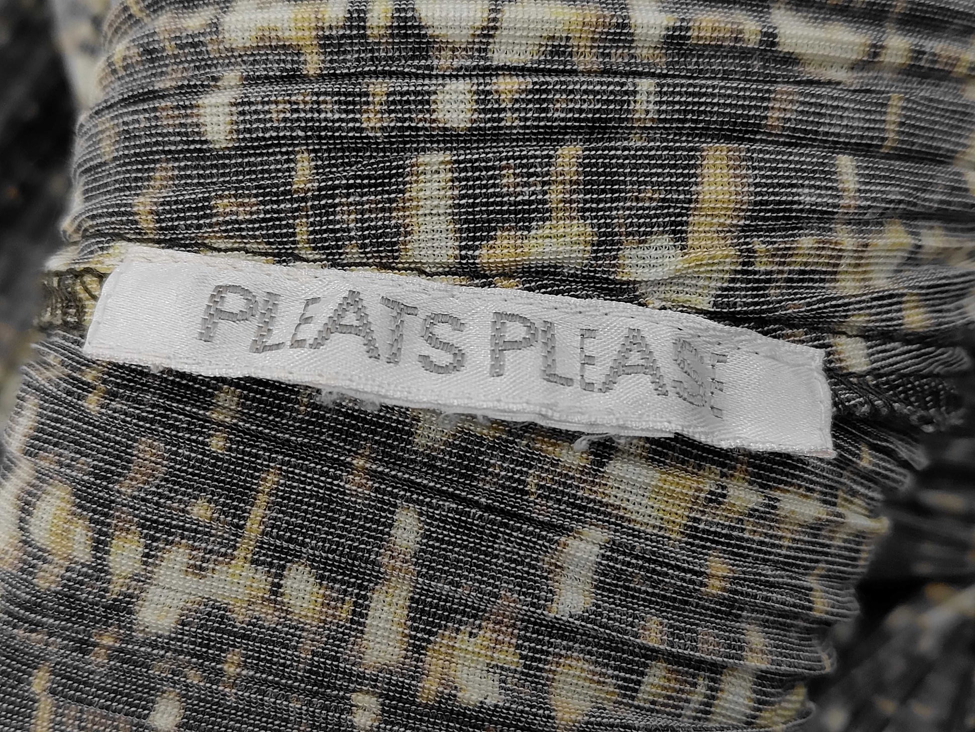 PLEATS PLEASE Issey Miyake long coat with fur collar and shoulder pads, all-over print