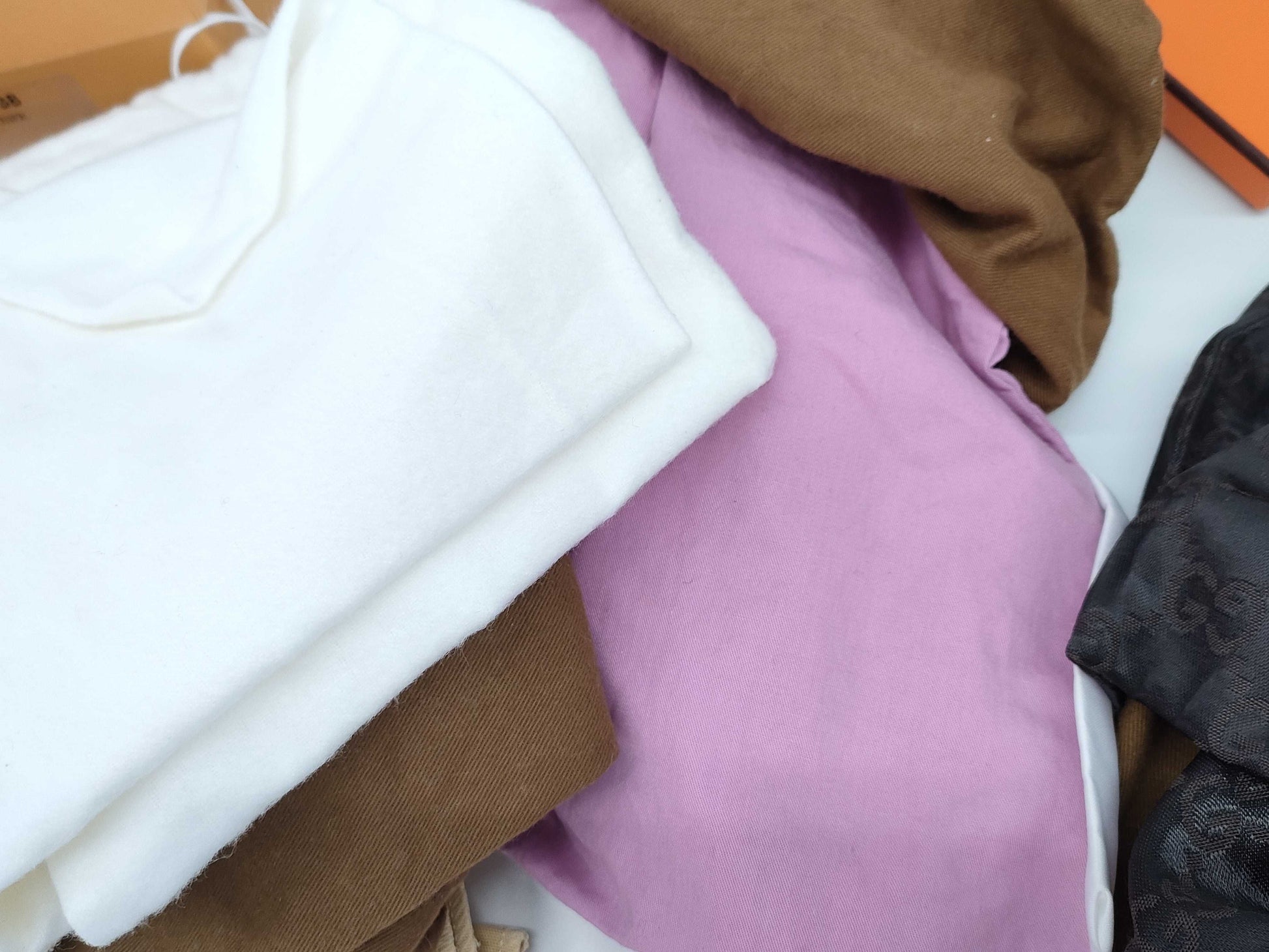 Empty Louis Vuitton, Gucci, Chanel, Loewe, and other brand-name boxes and dust bags. One M-tiered box. Empty brand-name boxes.